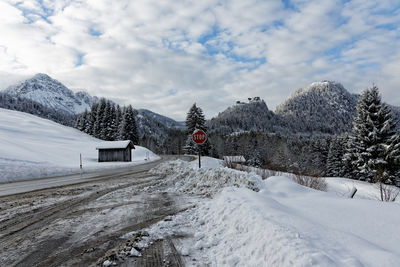 Snow covered trees by mountain against sky