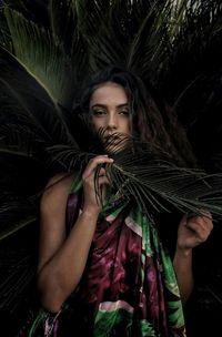 Portrait of beautiful young woman with plants