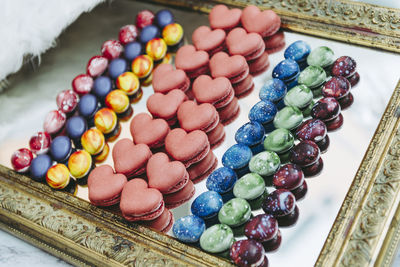 High angle view of macaroons and candies on mirror