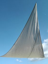 Low angle view of sailboat against clear blue sky