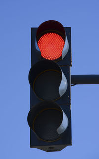 Low angle view of road sign against blue sky