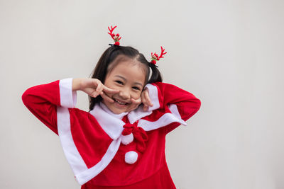 Portrait of young woman holding gift against white background