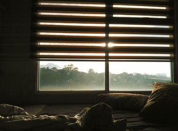 Man relaxing on bed seen through window at home