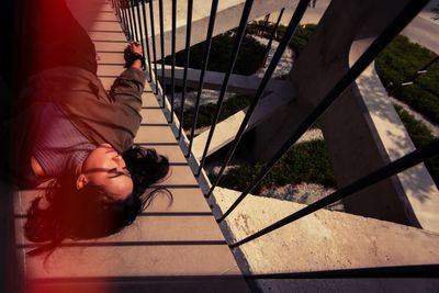 High angle portrait of woman relaxing on railing