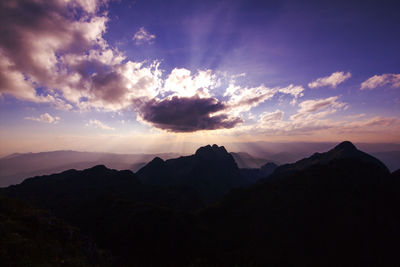 Silhouette mountains against dramatic sky during sunset