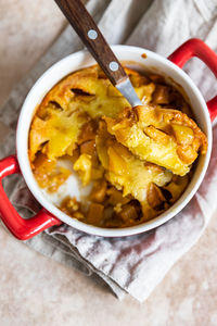 Dutch baby pancake with apples served with honey in ceramic baking dish. delicious sweet breakfast.