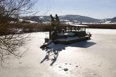 Horse cart on snowcapped mountain against sky