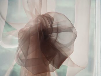 Close-up of beige curtain hanging at window