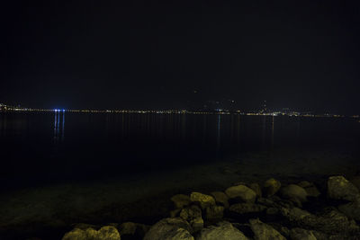 Illuminated river against sky at night