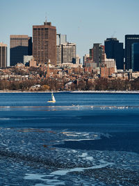 Buildings at waterfront against clear sky