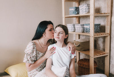 Mother kissing daughter at home