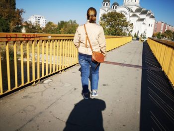 Rear view of man walking on footpath