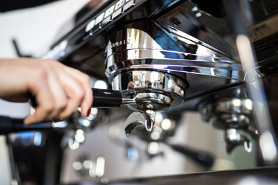 Close-up of person preparing coffee in cafe