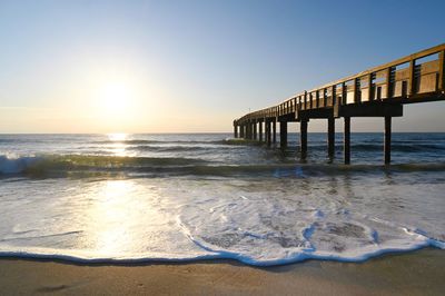 Pier over sea against clear sky