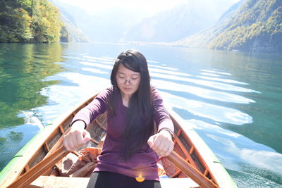 Young woman rowing boat in lake