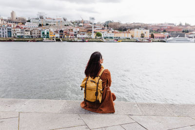 Rear view of woman sitting in city