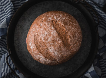 One rye round bread on a black background.