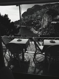 Chairs and table by trees against sky