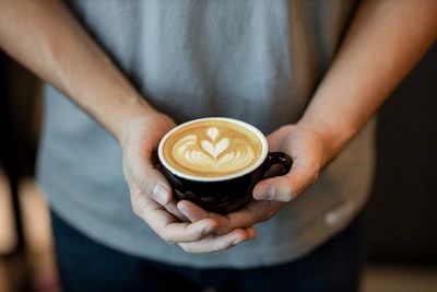 Cropped image of hand holding coffee cup