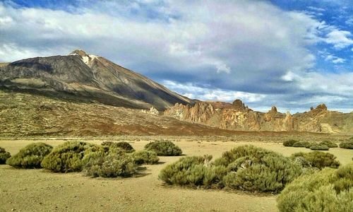 Scenic view of mountains against cloudy sky