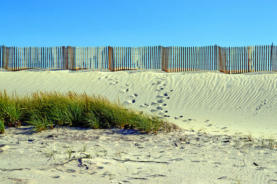 Scenic view of beach against clear blue sky