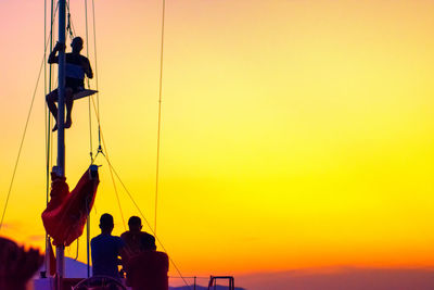 Rear view of silhouette people standing against orange sky