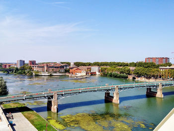 Scenic view of river by buildings against sky