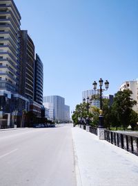 Road amidst buildings against sky in city