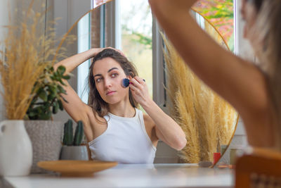 Portrait of young woman sitting at home