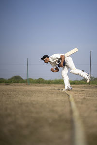 Young indian cricketer entering in the cricket field. indian cricket and sports concept.