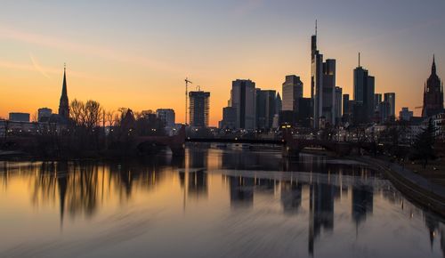 Reflection of buildings in city at sunset