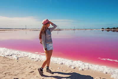 Young smiling woman tourist with long hair near saline pink lake. pink lagoons in mexico. person