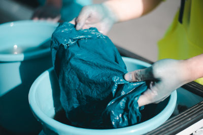 Midsection of person working in blue container