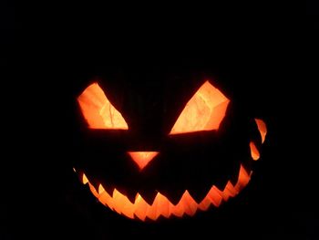 Close-up of illuminated pumpkin against black background