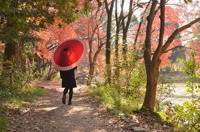 Rear view of woman standing on footpath