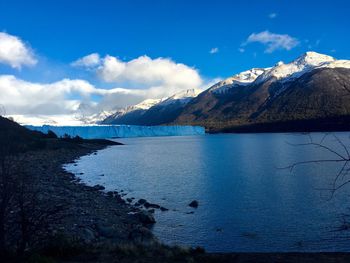 Scenic view of calm lake and snowcapped mountains against sky