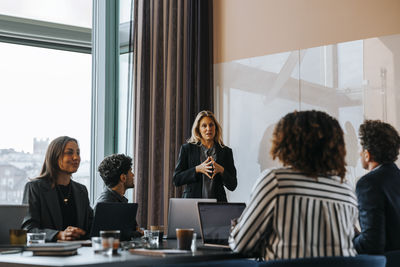 Female entrepreneur planning business strategies with colleagues in board room at office