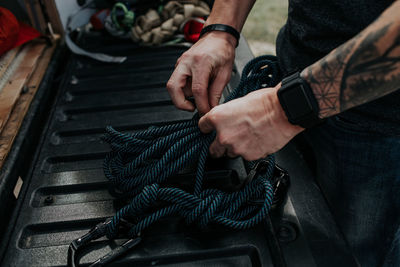 Close up of man prepping climbing ropes