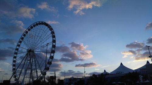 Low angle view of ferris wheel against sky at sunset