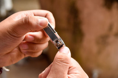 The child's hand is claw scissors cut the other fingernail.