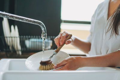 Midsection of woman midsection of woman cleaning dishes at home