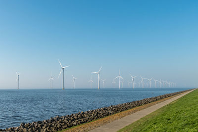 Windmills against clear blue sky