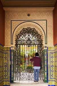 Rear view of man standing at entrance of building