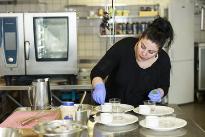 Woman preparing food in restaurant kitchen