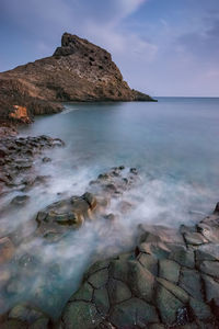 Scenic view of rocks in sea against sky