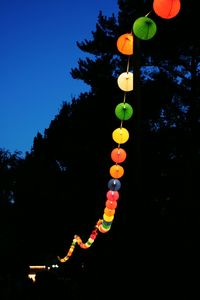 Low angle view of illuminated hanging against sky at night