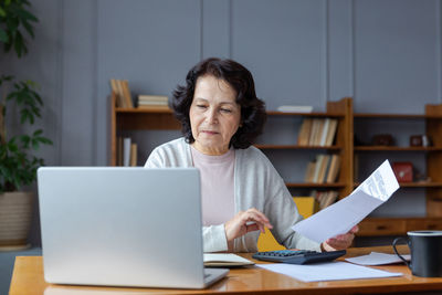 Young woman using laptop at table