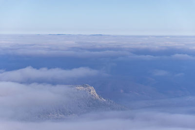 Aerial view of clouds over mountain against sky