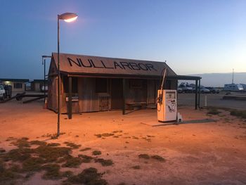 Lifeguard hut on street against clear sky during sunset