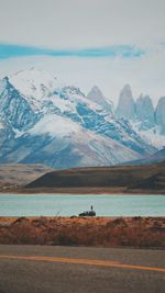 Scenic view of snowcapped mountains by sea against sky